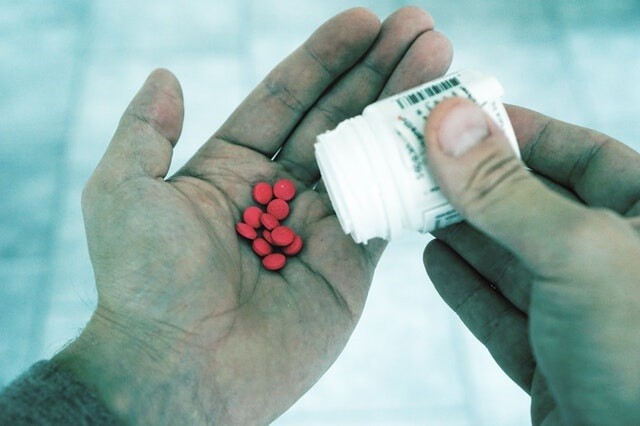 a man pouring pills into his hand